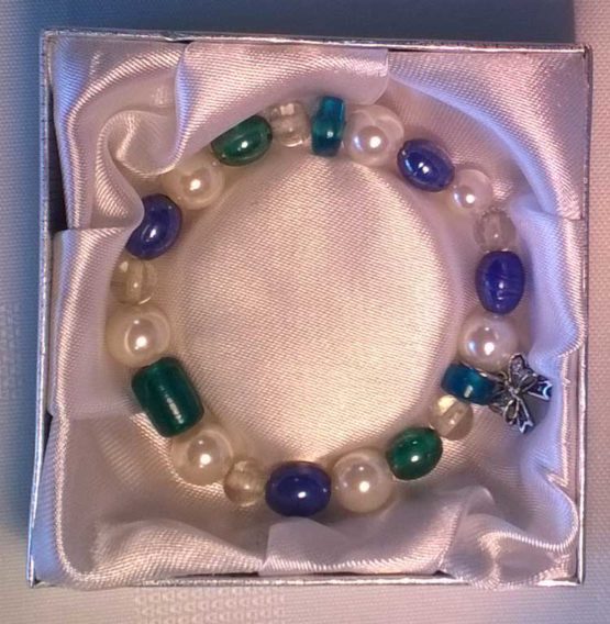 Blue, green and white beaded bracelet laid in padded box