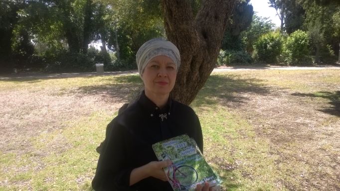 Shoshanah Shear in Park with a copy of Healing Your Life Through Activity